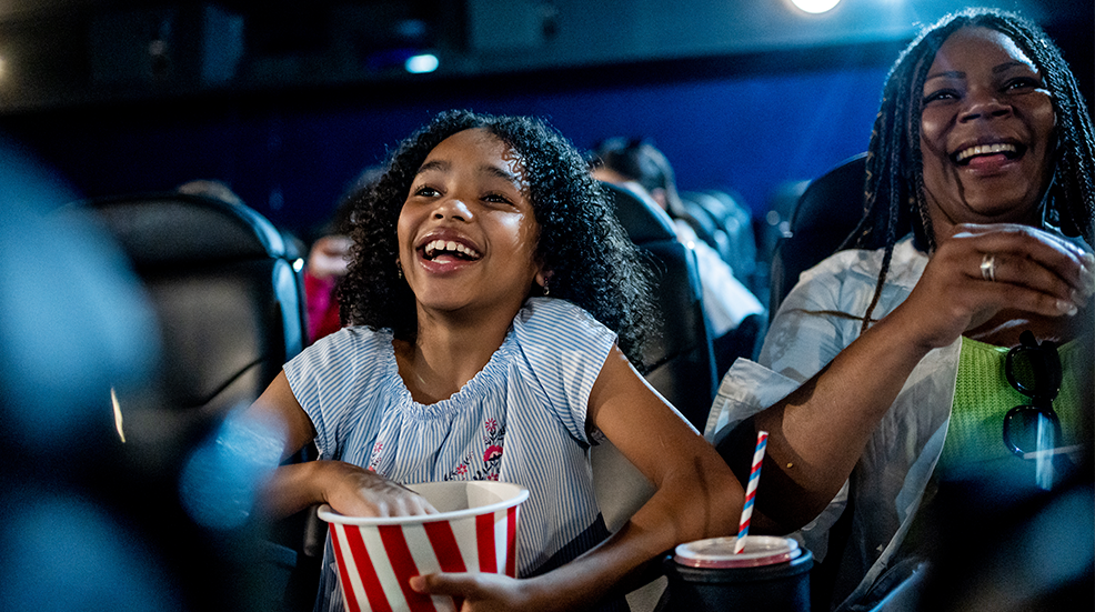 Excited girl watching movie in cinema